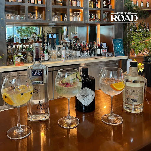A selection of premium gins and gin-based cocktails arranged on a polished wooden bar at Brittany Hotel BGC, showcasing the sophisticated drinking experience.