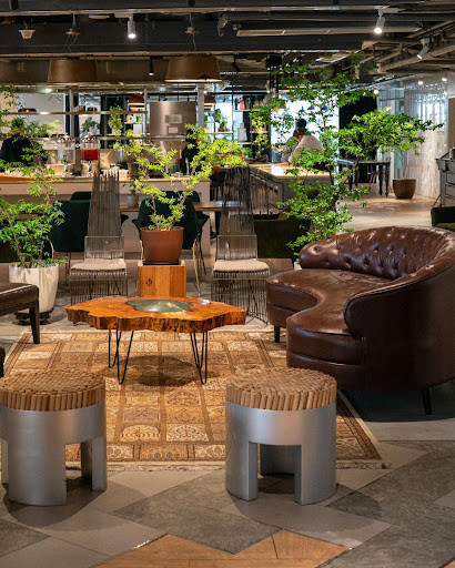 Sophisticated lounge area with a large leather armchair, a live-edge wooden coffee table, and lush indoor plants.