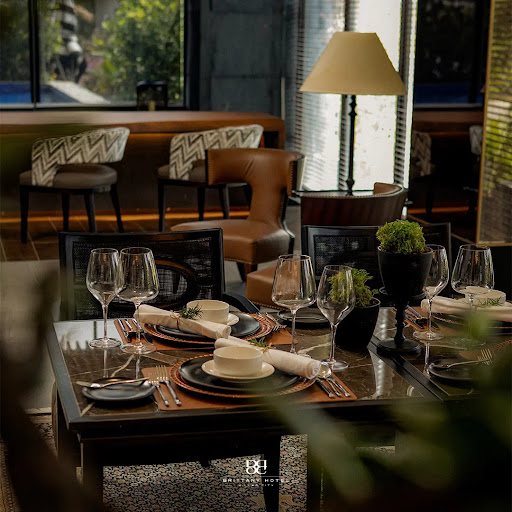 Interior of a modern, stylish hotel restaurant. Warm lighting, comfortable seating, elegant decor. A mix of contemporary and classic design elements. The atmosphere is relaxed yet refined. Brittany Hotel Villar City style.